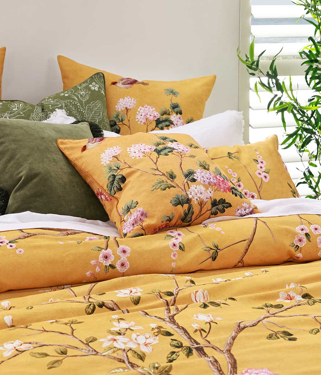 Opulent and artistic, M.M Linen Yuki design of charming blossoms and fauna on a sunny and soft, golden background