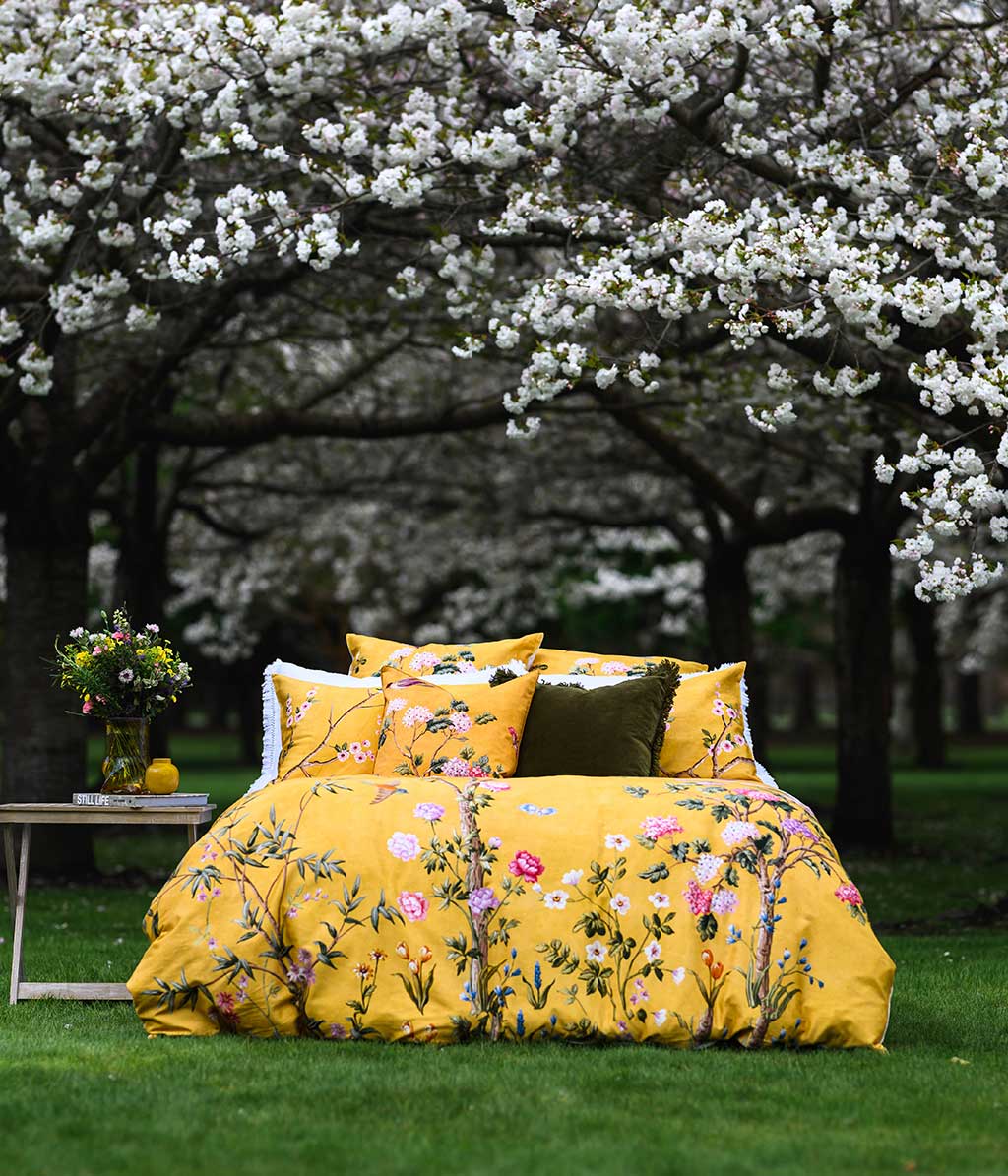 Opulent and artistic, M.M Linen Yuki design of charming blossoms and fauna on a sunny and soft, golden background